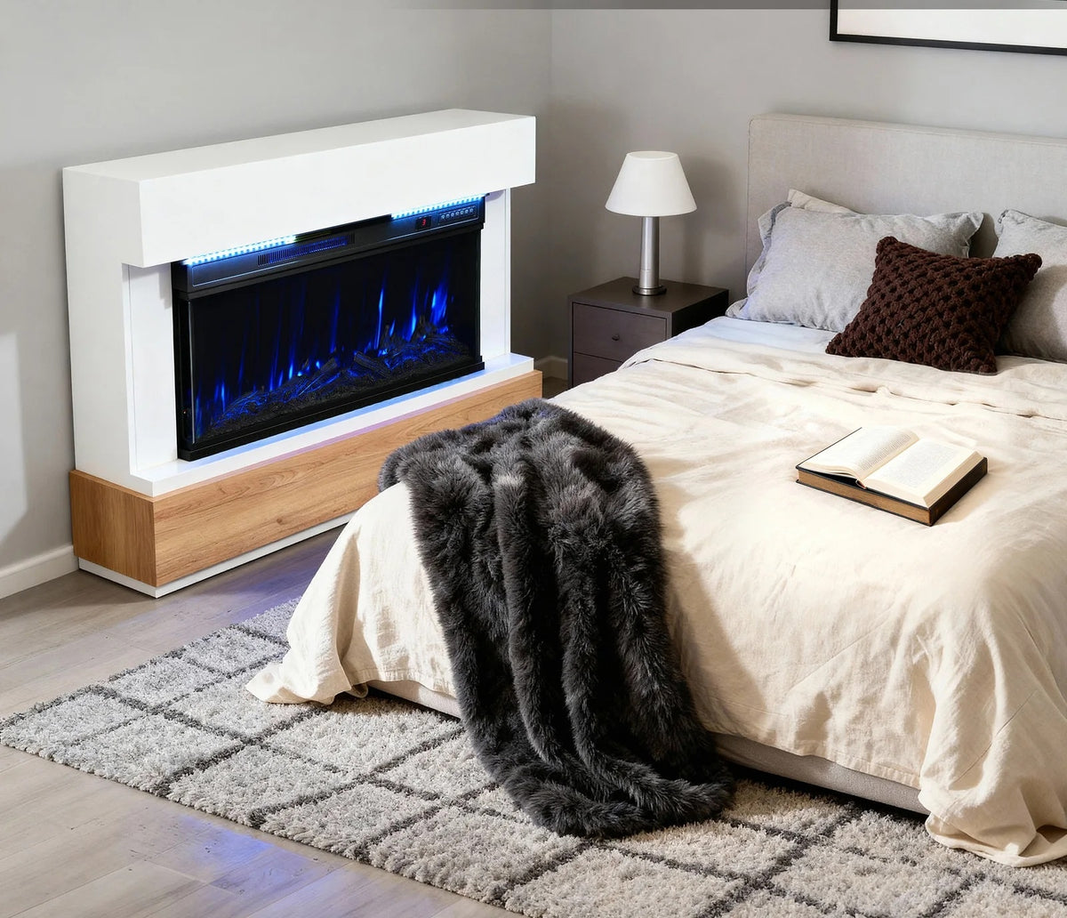 Cheminée électrique panoramique, manteau blanc et socle bois, dans une chambre